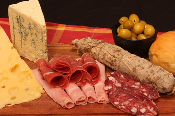 Food tray with delicious salami, pieces of sliced ham and chesses
