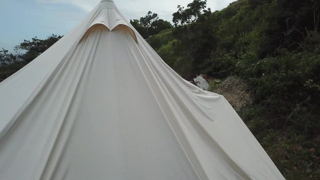 AERIAL: rotating and lifting around a tent in the mountain tops of Utuado, Puerto Rico.
