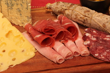 Food tray with delicious salami, pieces of sliced ham and chesses