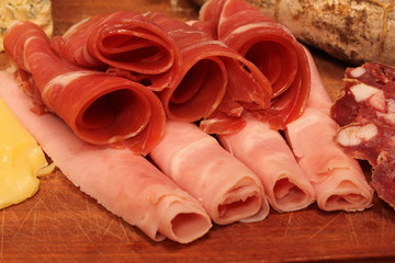 Food tray with delicious salami, pieces of sliced ham and chesses