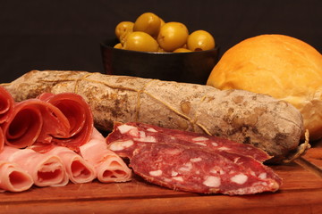 Food tray with delicious salami, pieces of sliced ham and chesses