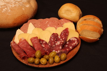 Food tray with delicious salami, pieces of sliced ham and chesses