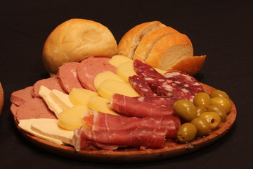 Food tray with delicious salami, pieces of sliced ham and chesses