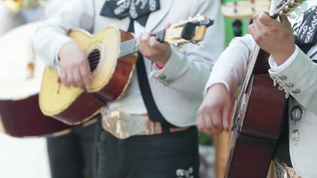 Three mexican mariachi musitian playin g the guitar, Vihuela and acoustic bass