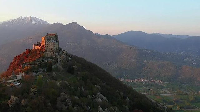 The Sacra di San Michele (Saint Michael's) Abbey, Turin, Italy, sunset shot aerial with mountains of Susa valley in background. Aerial view