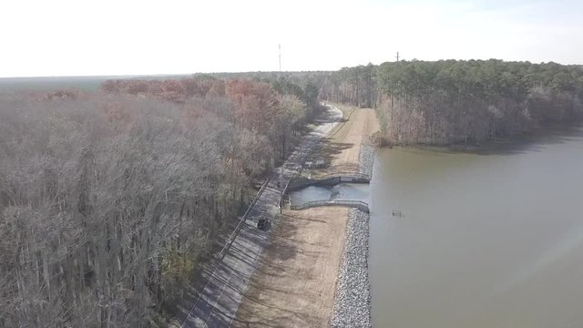 Aerial flight along a peaceful country road and lake.