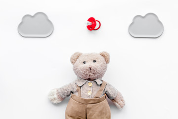 Baby care. Newborn baby concept. Teddy bear toy near pacifier on white background top view copy space