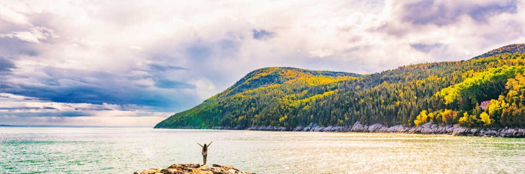 Autumn Fall nature landscape mountains banner background in Quebec, Canada. St Lawrence river in Charlevoix region, North America. Tourist person with arms up open in freedom happy of travel holidays.