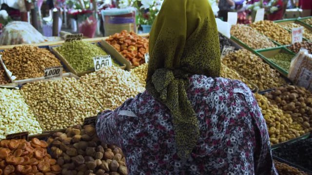 Kyrgyz woman buying dry fruits in slow motion