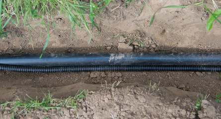 plastic pipe lies in the trench for the supply of communication to the house