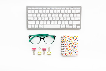Office desk in order. Geometry. Computer keyboard and office supplies, glasses on white background top view