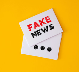  stacking of FAKE NEWS on white business card