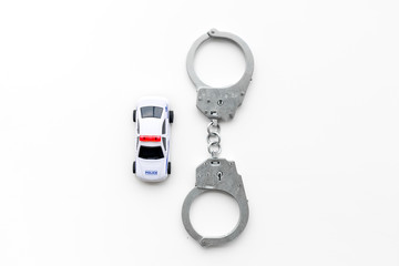 Police concept. Police car toy and handcuff on white background top view copy space