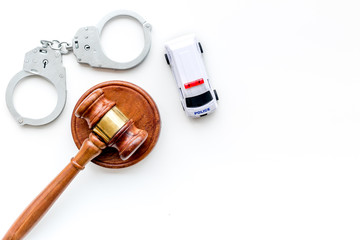 Crime concept. Police car toy, handcuff, judge hammer on white background top view copy space