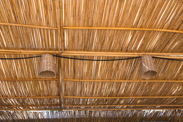 Lighting and illumination concept - Lamps ceiling lights are hanging from bamboo roof.