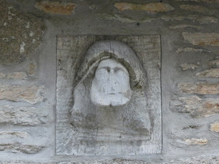 Visage sculpté dans une poutre .