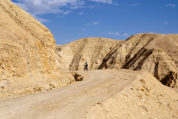 Lonely cyclist on the desert road, Judean Desert, Israel