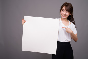 Asian woman showing empty white board with copyspace
