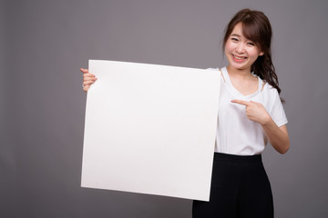 Naklejka premium Asian woman showing empty white board with copyspace