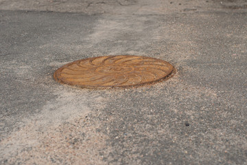 rusty sewer hatch on the road