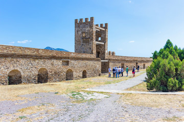 Obraz premium Genoese fortress in Sudak, Crimea. Tourists see the Pasquale Judiche tower.