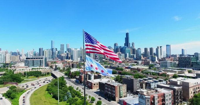 Aerial drone shot of Chicago downtown above the highway with american flag. USA Flag in the middle.