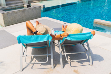 Couple on sunbeds by the swimming pool