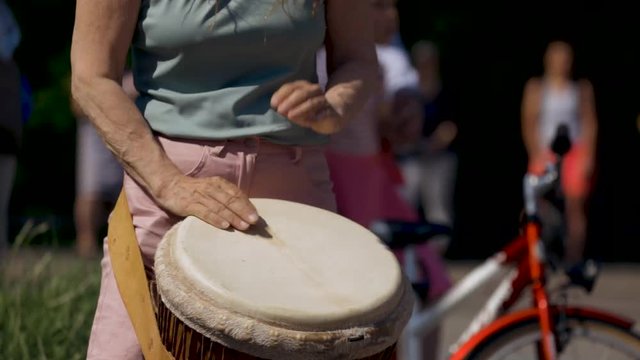 Woman playing hand drum during a marathon.