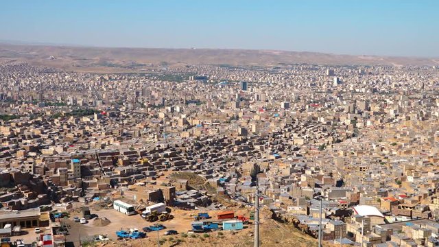 Birds eye view showing the sprawling city of Tabriz in Iran. Shanty towns sit on the outskirts of the city, with new developments closing in on them.