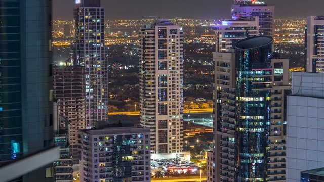 Dubai marina and JLT skyscrapers aerial skyline night timelapse. Great perspective of multiple tallest towers. Top view from JBR. United Arab Emirates.