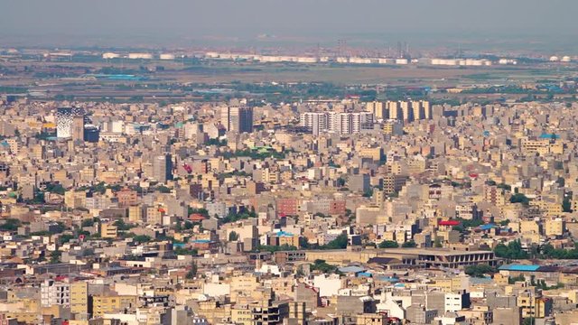 Hand held view of Tabriz from a high angle, showing the industrial area in the distance behind the city.