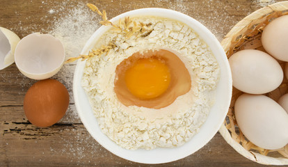 eggs and flour on wooden table,egg,food,breakfast,flour,white,meal,cooking,bowl,raw,fried,healthy,baking,ingredient,ingredients,bread,fresh,plate,isolated,kitchen,broken.