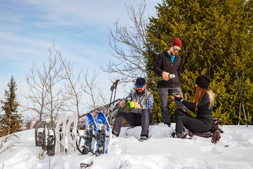Travelers rest in the winter in the mountains. The company of young people on a halt.