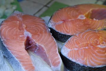 Raw salmon fillet. Three fresh salmon steaks. Cooking. Cutting board. White paper.
