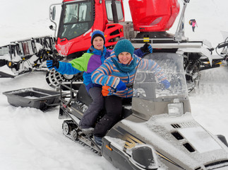 Lead sit on a snowmobile on a snow slope.