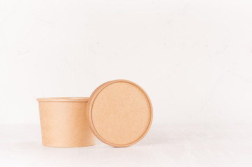 Cardboard box for soup, ice cream, fast food and circle cap on white wooden board, copy space, concept design pack for go food for restaurant, cafe, shop, advertising.