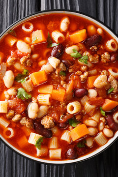 Delicious Italian Pasta fagioli soup with vegetables and ground beef close-up in a bowl. Vertical top view