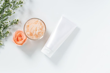 skin care concept. flat lays of skincare remedies style in white squeeze tube package with blank label and salt spa in glass bowl with natural materials isolated on white background