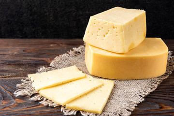 Cheese on dark wooden background.