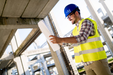 Picture of construction site engineer looking at plan