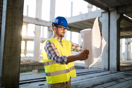 Picture of construction site engineer looking at plan