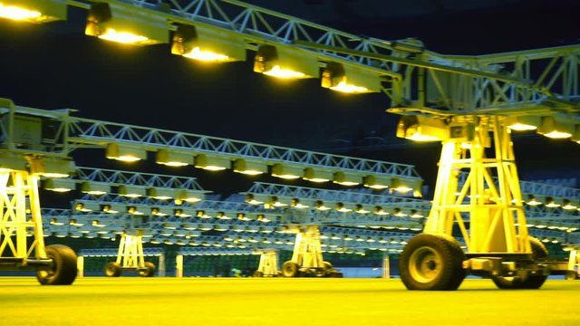 Mobile grow lighting system in sports stadium at night.
