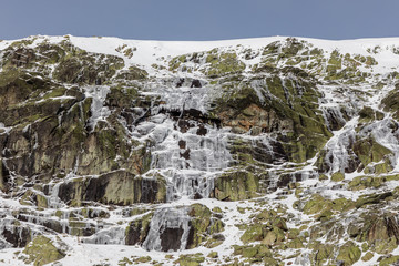 Fototapeta na wymiar rocks covered with ice, water and snow in the mountains of Madrid