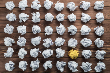 Concept of creativity and inspiration presented by many white paperballs and one color