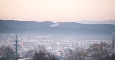 Fototapeta na wymiar Winter dawn and the frosty fog. Morning in the northern town.