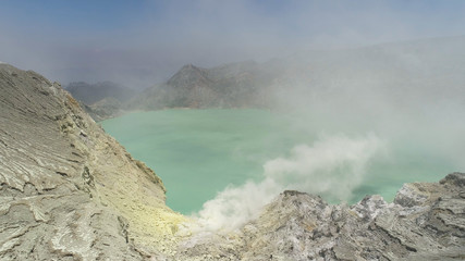 Aerial view mountain landscape with crater acid lake Kawah Ijen where sulfur is mined. Sulfur gas, smoke. Ijen volcano complex group of stratovolcanoes in East Java Indonesia