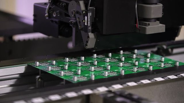 Electronic circuit board production. Automated circut board machine produces printed digital electronic board. Manufacture of electronic chips. Close up. High-tech