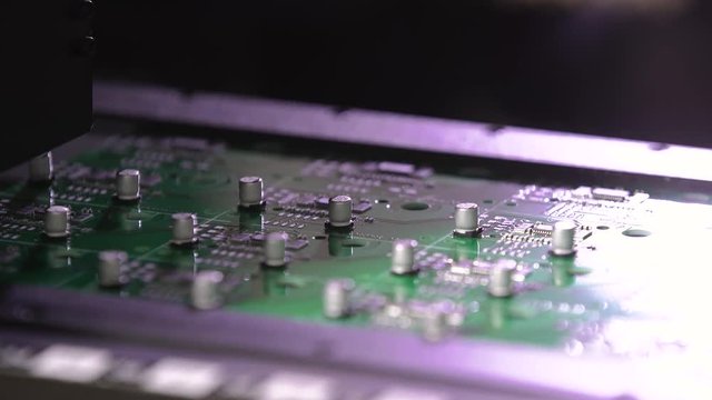 Electronic circuit board production. Automated circut board machine produces printed digital electronic board. Manufacture of electronic chips. Close up. High-tech