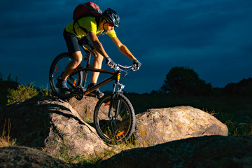 Cyclist Riding the Mountain Bike on Rocky Trail in the Evening. Extreme Sport and Enduro Biking...