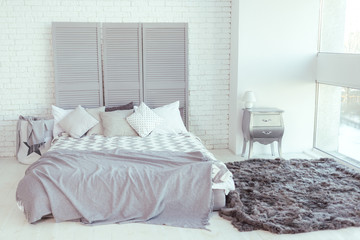 Bedroom interior with light gray bed and white walls